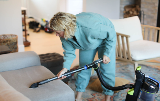 Sarah McAllister vacuuming a couch