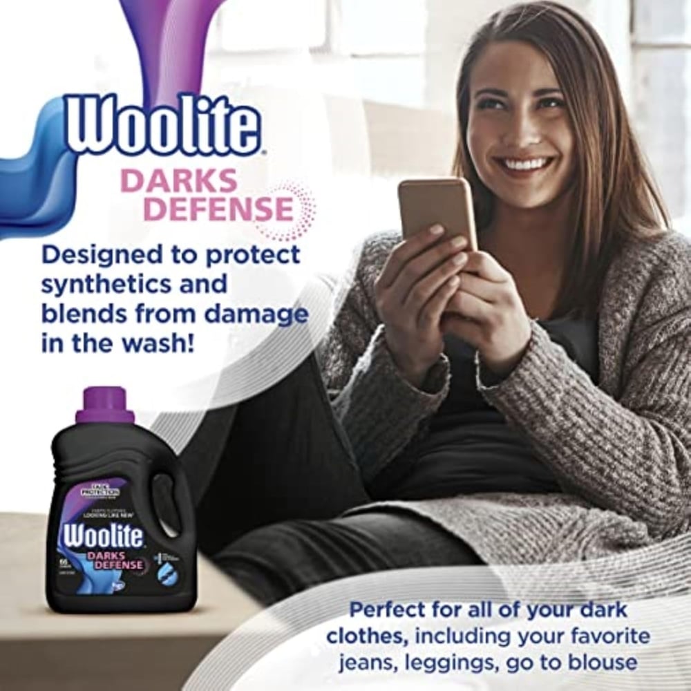 Woolite Darks Defense advertisement showing a bottle of Woolite on the left and a smiling woman holding a phone on a couch, with the text about protecting synthetics in the wash.