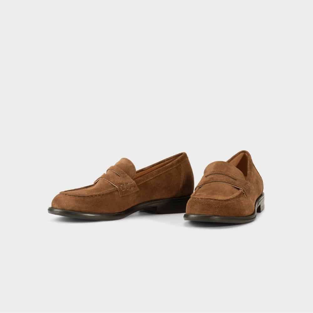 Brown suede penny loafers pair on a light background