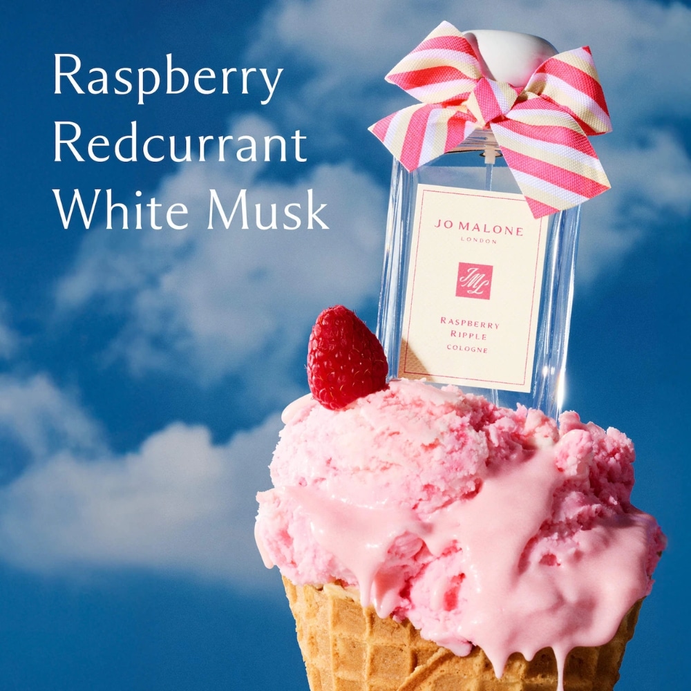 Fragrance ad showing a pink raspberry ice cream cone and a perfume bottle with a pink bow; notes read Raspberry Redcurrant White Musk.