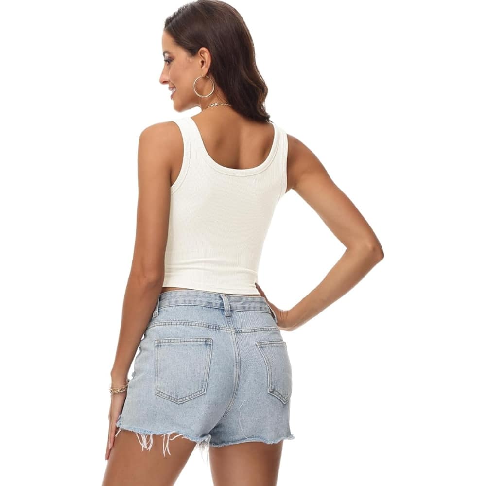 Back view of a woman wearing a white ribbed tank top and frayed light-wash denim shorts, facing away.