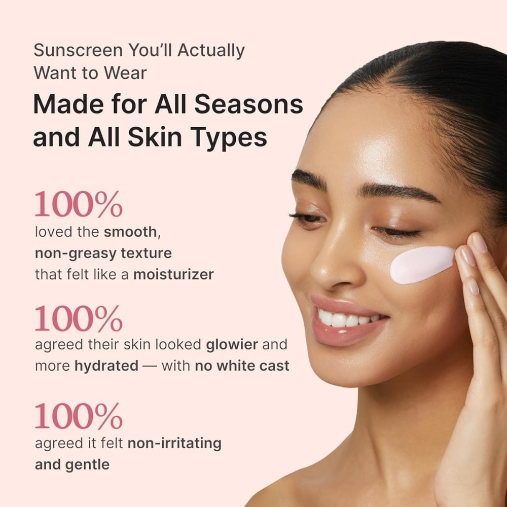 Advertisement for sunscreen; smiling woman applies pink moisturizer under her eye on a pale pink background with bold text about all seasons and all skin types.