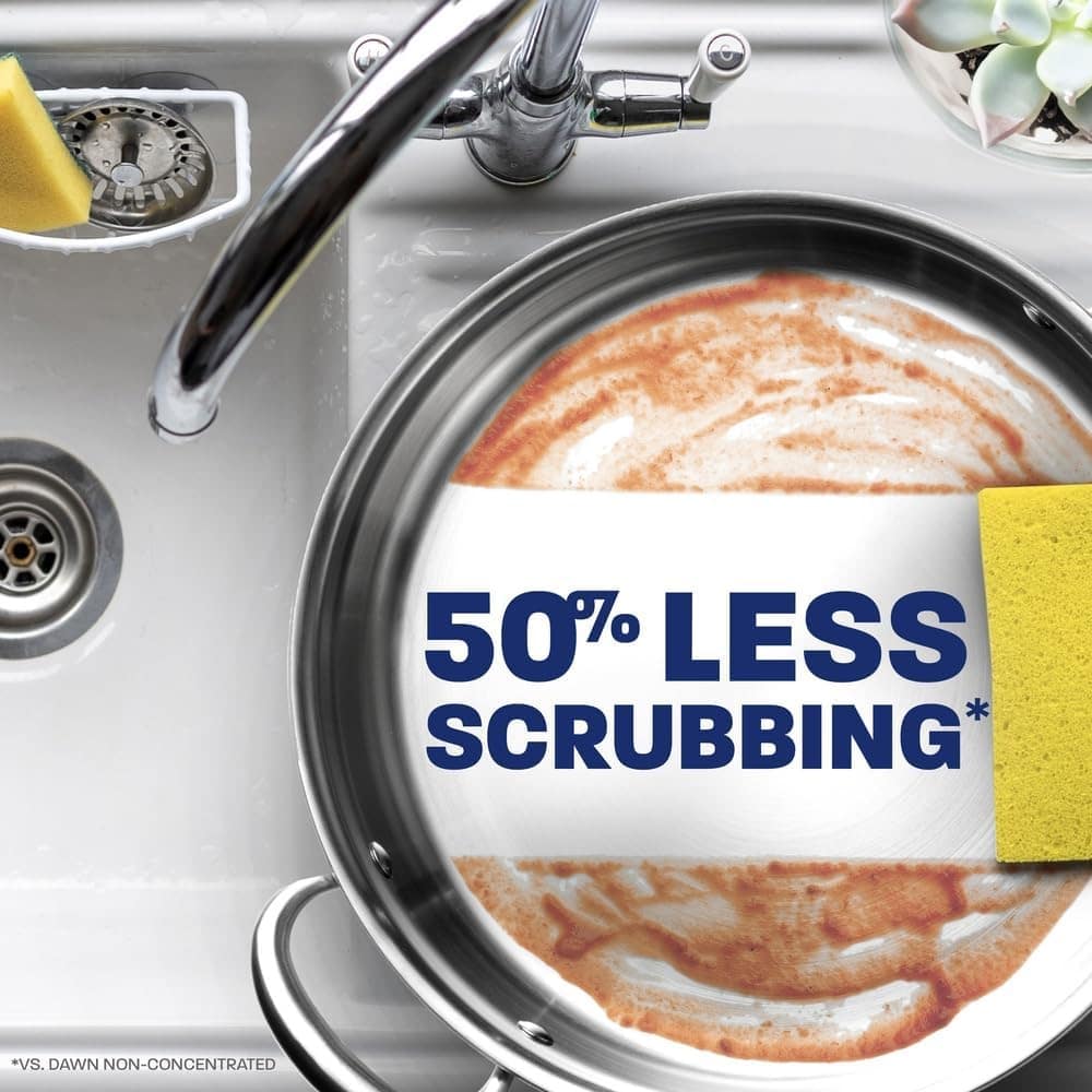 Pan in a kitchen sink with a yellow sponge and a label that reads '50% LESS SCRUBBING', advertising less cleaning effort.