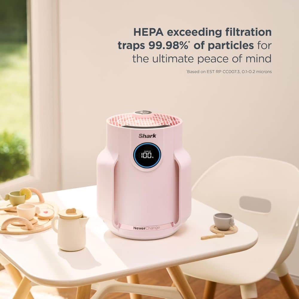 Pink Shark air purifier on a white table with a toy tea set, featuring text about high-HEPA filtration efficiency.
