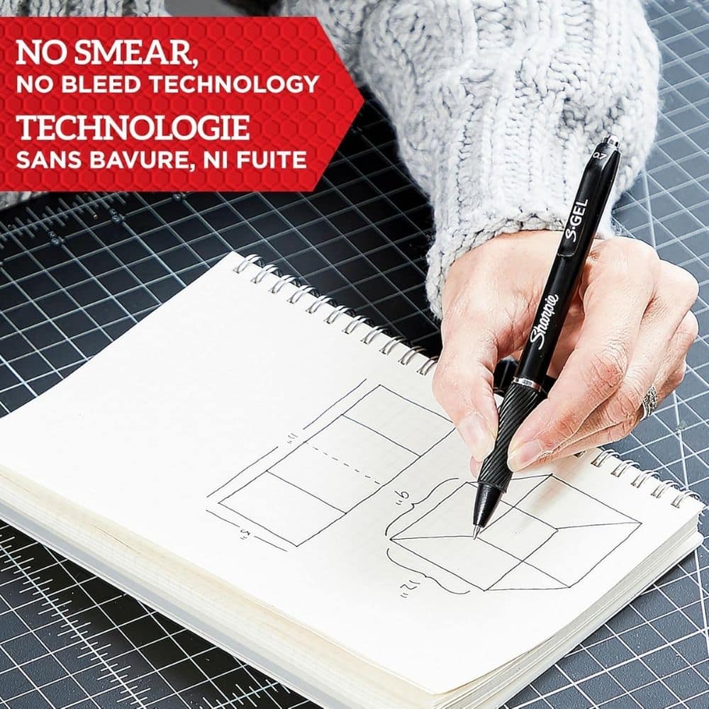 Person sketching geometric diagrams in a spiral notebook with a black marker; red banner reads 'NO SMEAR, NO BLEED TECHNOLOGY' at top left.