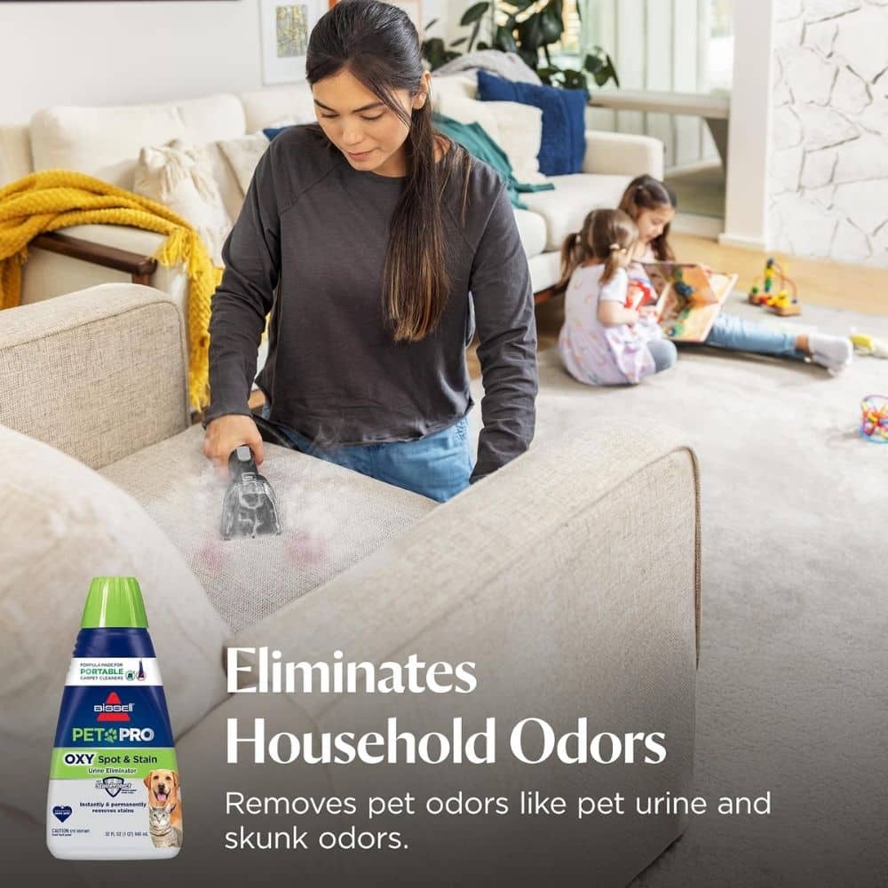 Woman vacuuming a sofa while two children play in the living room; a bottle of pet odor eliminator appears in the foreground with the ad text 'Eliminates Household Odors'.