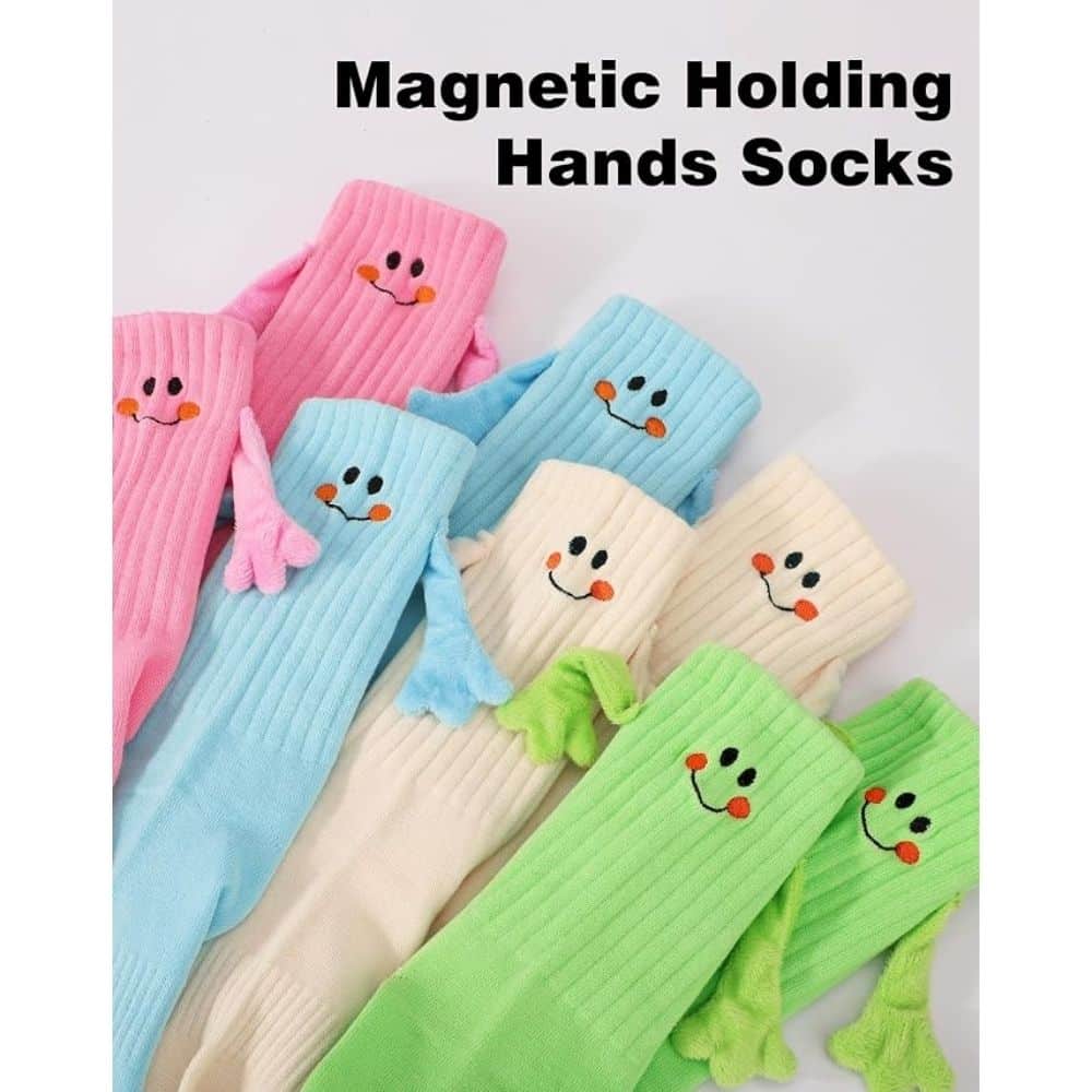 Colorful ribbed socks with smiling faces in pink, blue, beige, and green, arranged together; banner reads 'Magnetic Holding Hands Socks'.