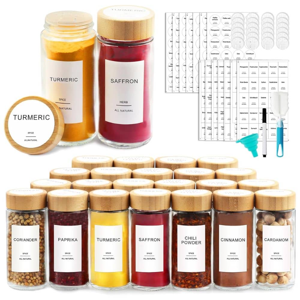Glass spice jars with wooden lids, labeled turmeric, saffron, coriander, paprika, chili powder, cinnamon, and cardamom, arranged in rows